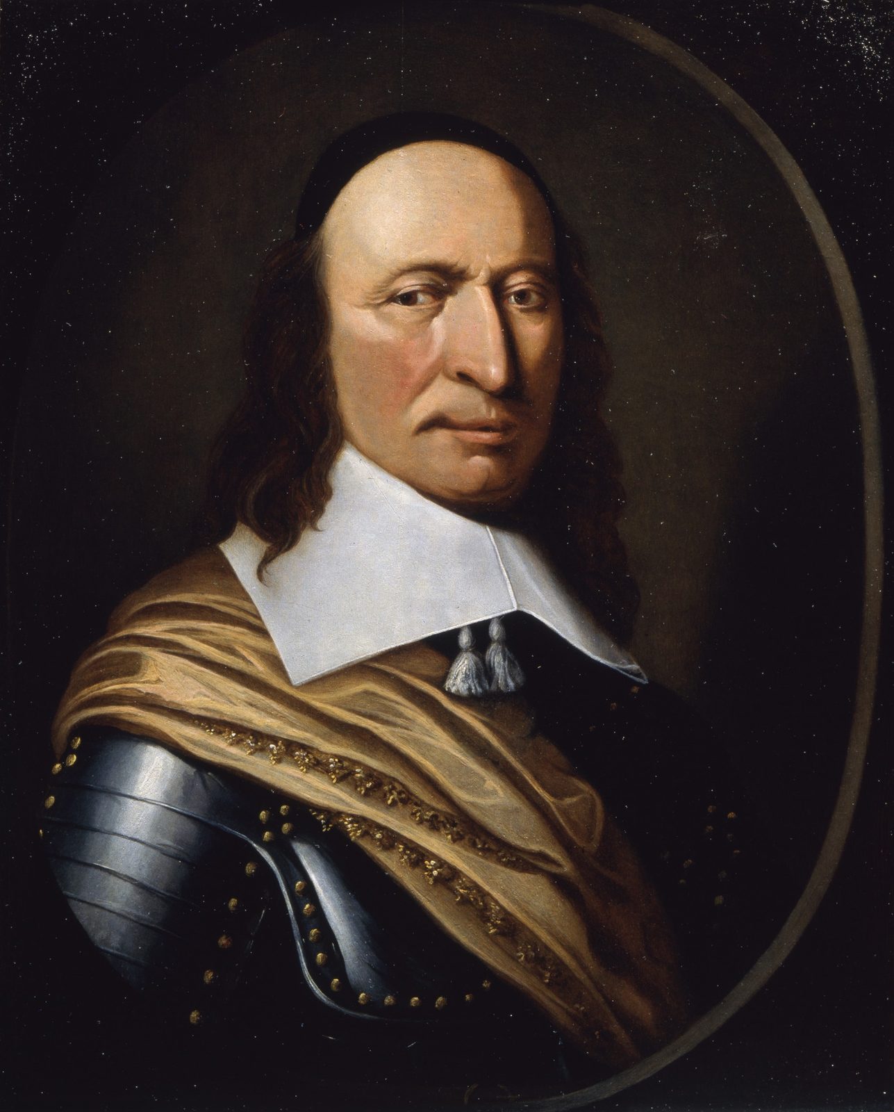 A small oil portrait in an oval, head and shoulders against a dark ground. A heavy-featured man in late middle age with a long nose, a downturned mouth and shoulder-length brown hair under a black skullcap, wearing a broad white falling collar with two tasselled cords, a gilt-studded steel shoulder-piece and a draped buff sash.